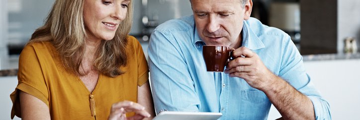 A mature couple goes over financial paperwork at home.