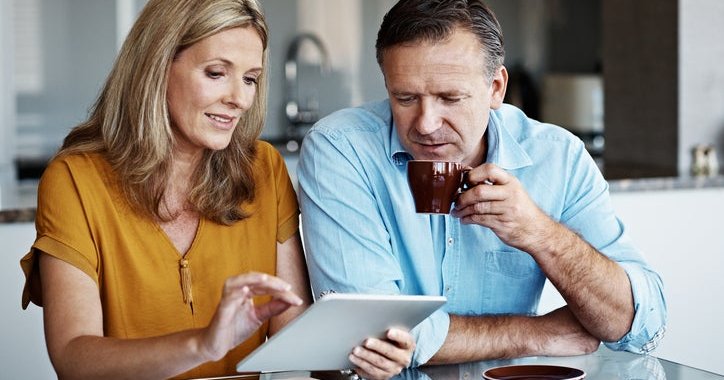 A mature couple goes over financial paperwork at home.