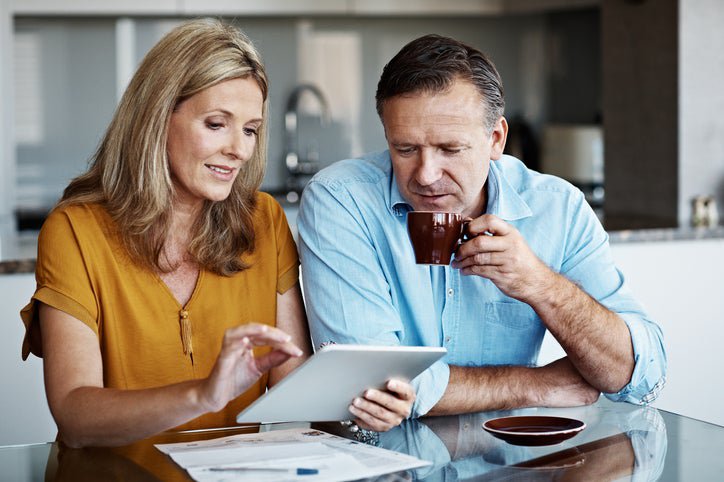 A mature couple goes over financial paperwork at home.