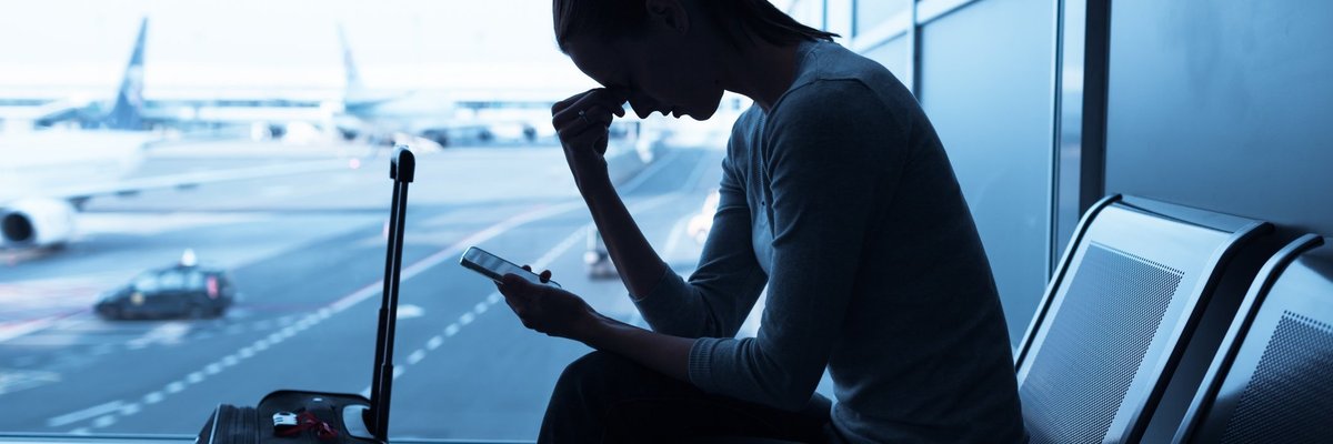 Woman with head in hand at airport