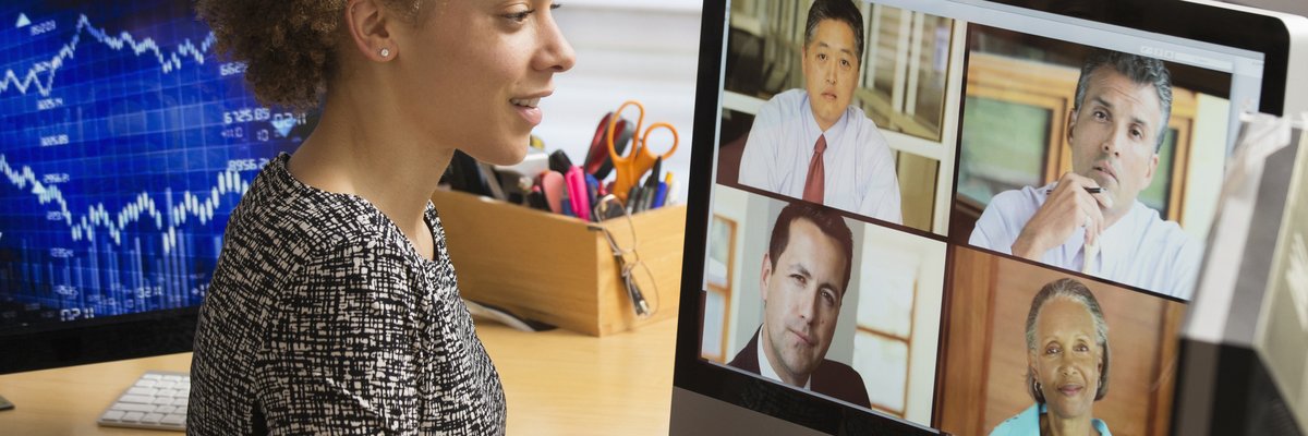 Business worker teleconferences their coworkers from a home office.