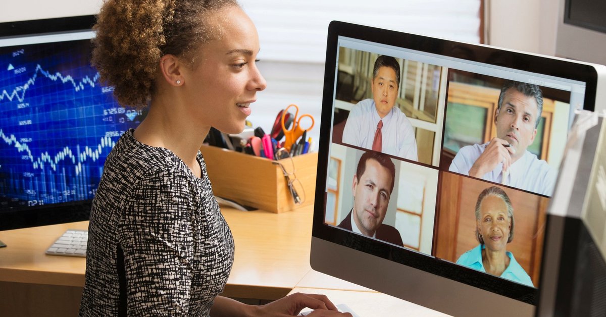 Business worker teleconferences their coworkers from a home office.