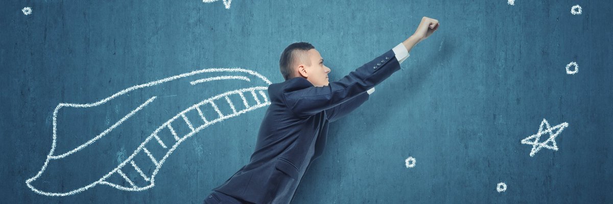 Man in suit in flying pose against wall featuring a chalk-drawn cape and dollar sign.