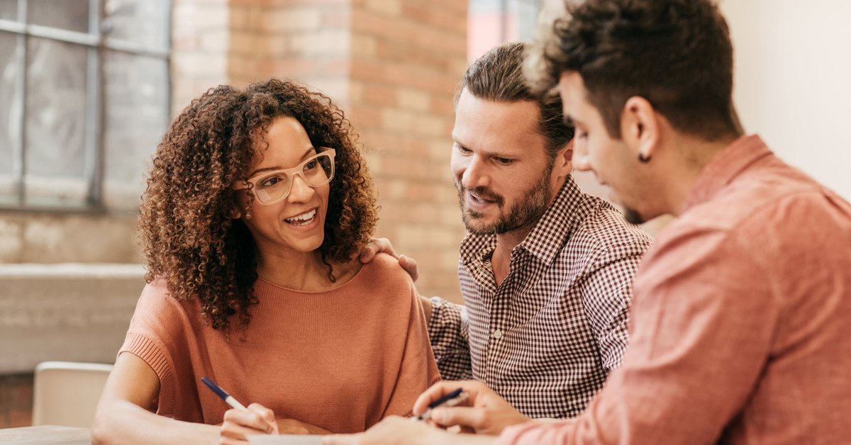 A couple meets with a financial advisor in their office.