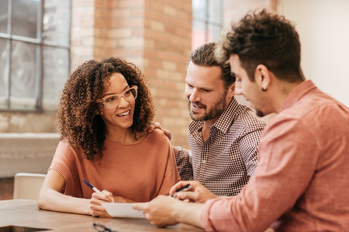 A couple meets with a financial advisor in their office.