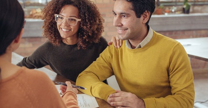 Smiling couple discuss paperwork.