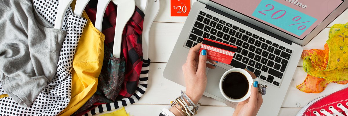 Person with coffee and credit card online shopping on laptop.