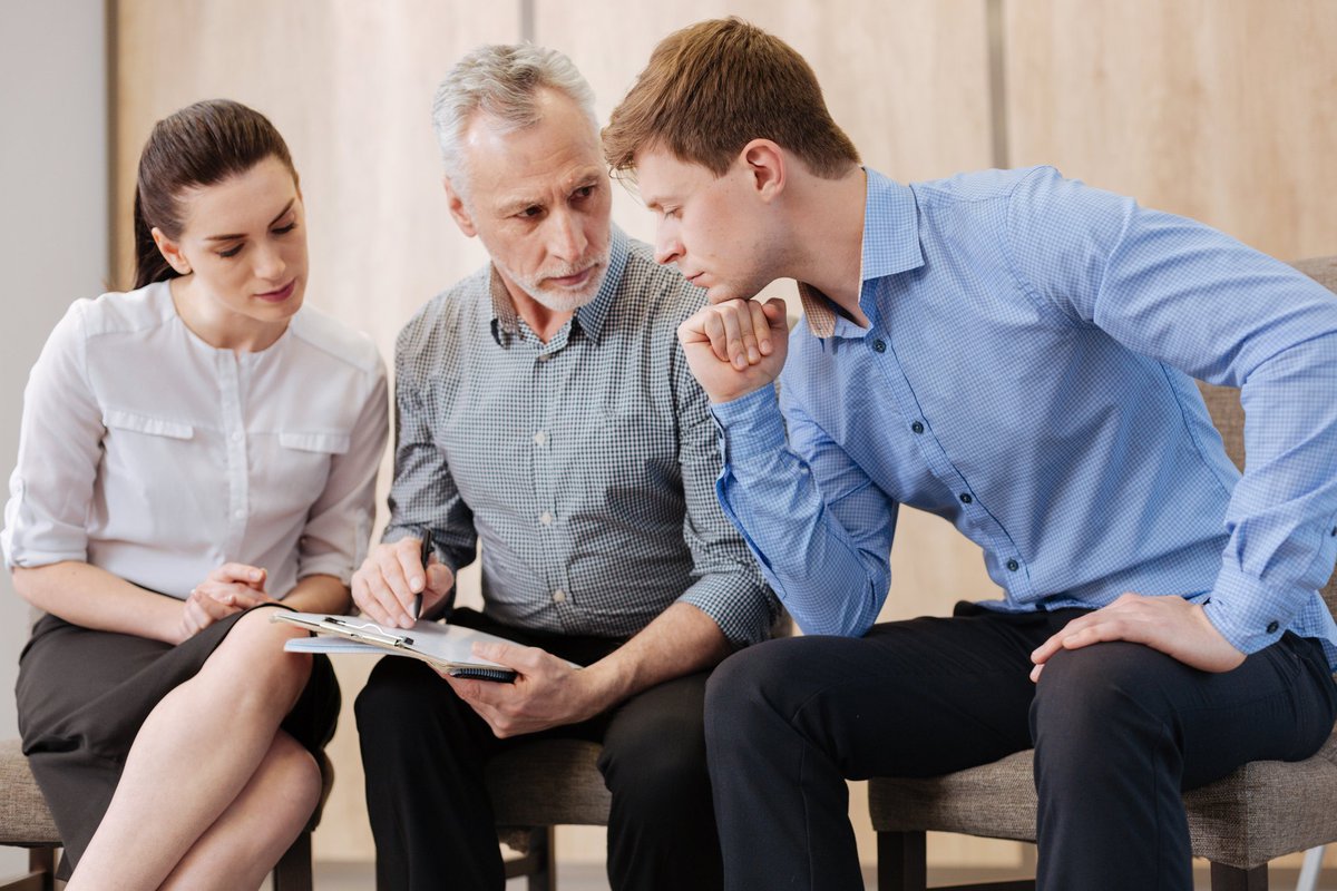 Baby boomer having a fraught discussion with two millennials.