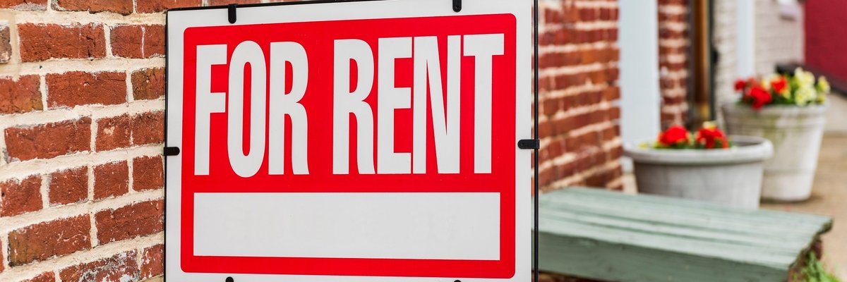 "for rent" sign outside of brick building