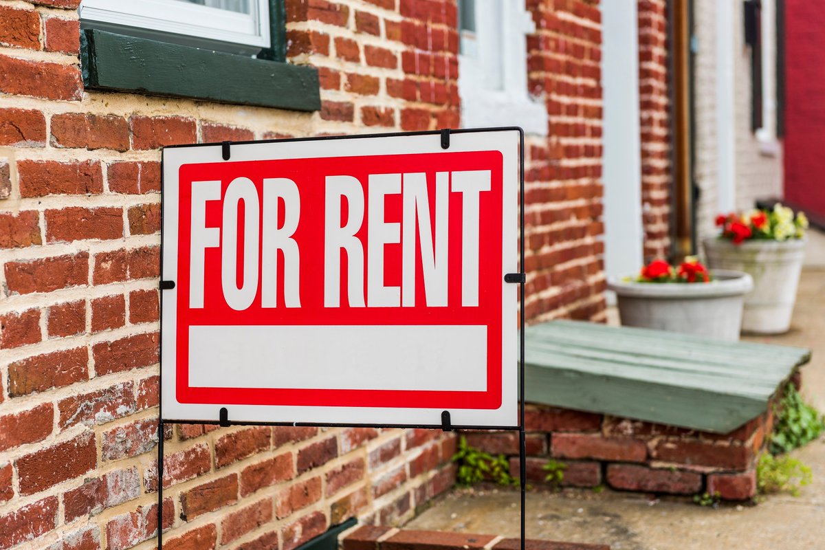 "for rent" sign outside of brick building