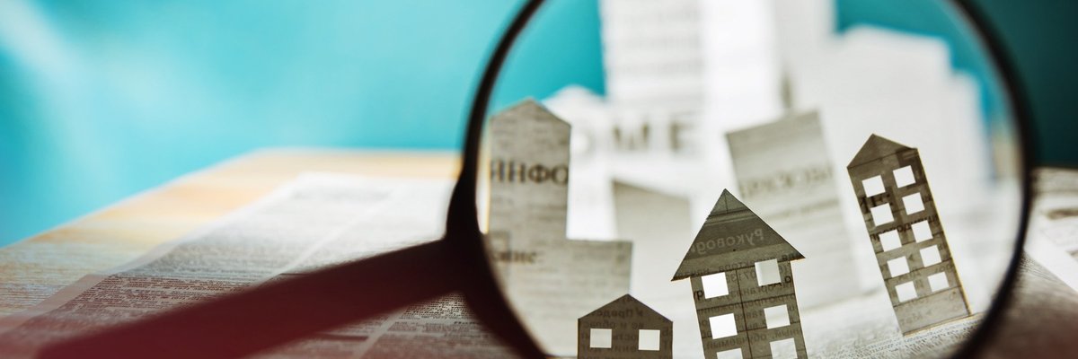 Magnifying glass over a paper house