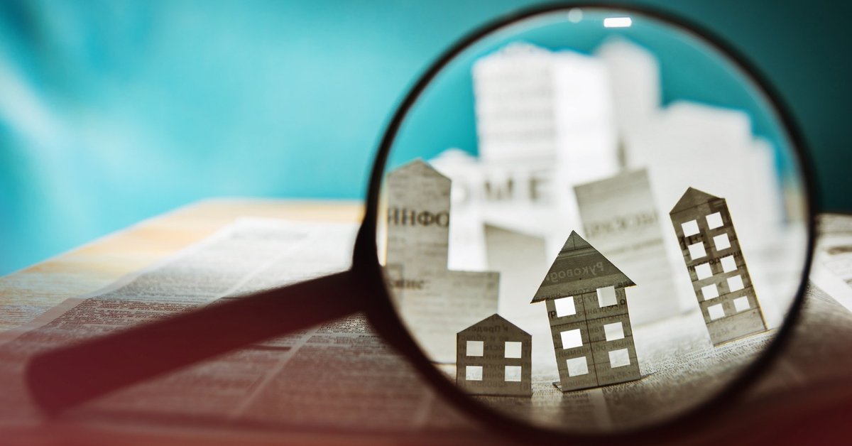 Magnifying glass over a paper house