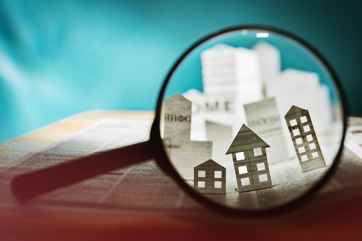 Magnifying glass over a paper house