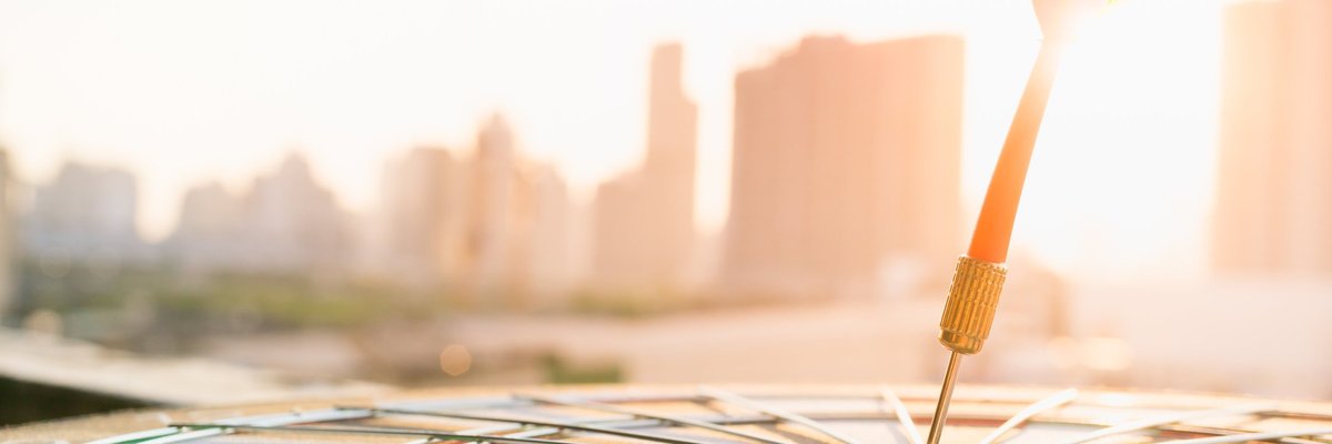 An arrow hits a bullseye amid a sunlit cityscape.