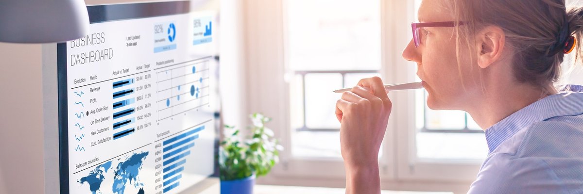 Woman reading at a computer in a sunny office.