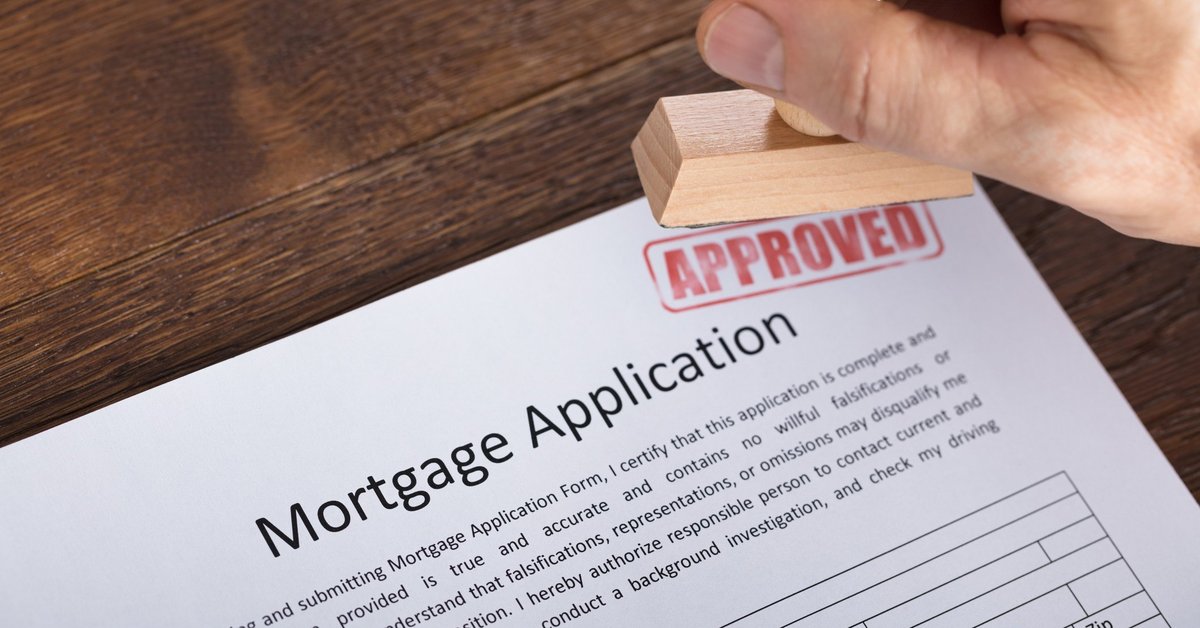 A mortgage application being marked with a stamp that says APPROVED