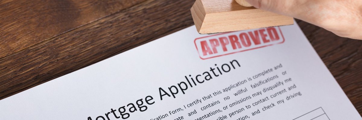 A mortgage application being marked with a stamp that says APPROVED