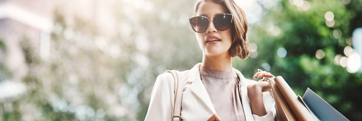 Well-dressed woman carrying multiple shopping bags.
