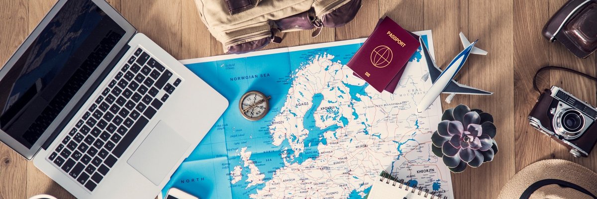 Map of Europe with laptop, phone, passport, and notebook