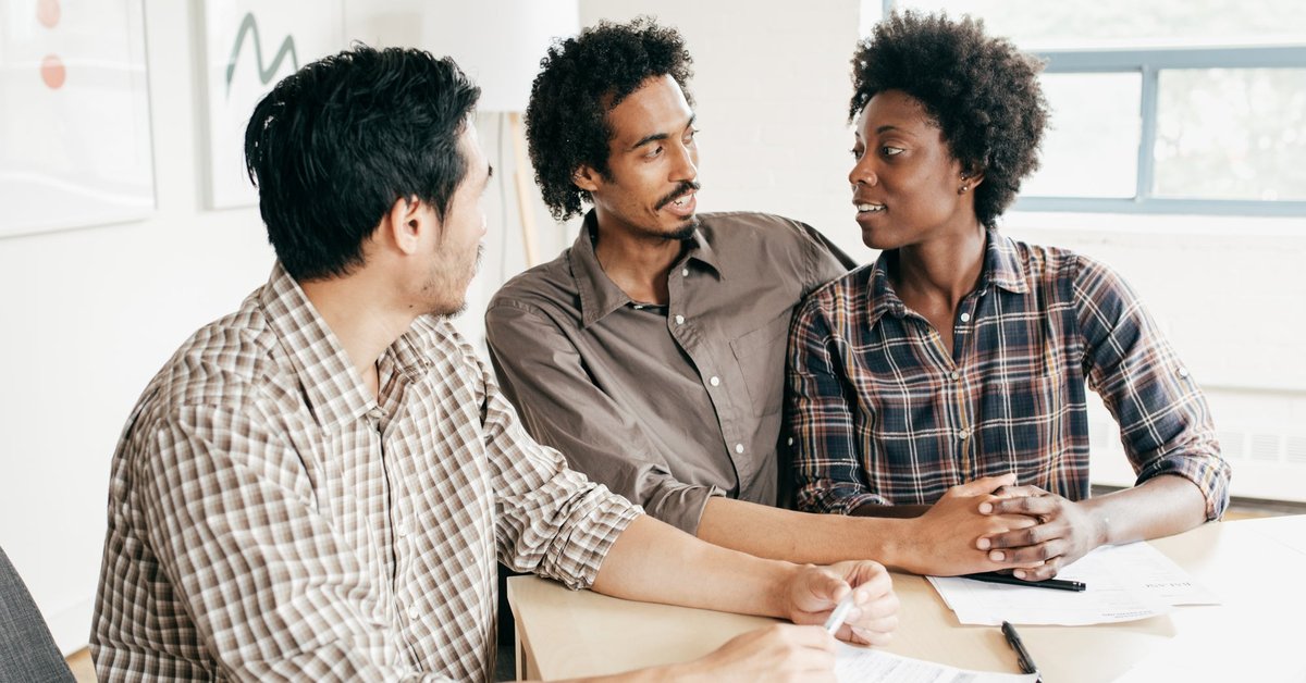 A couple meets with a banker to discuss their finances.