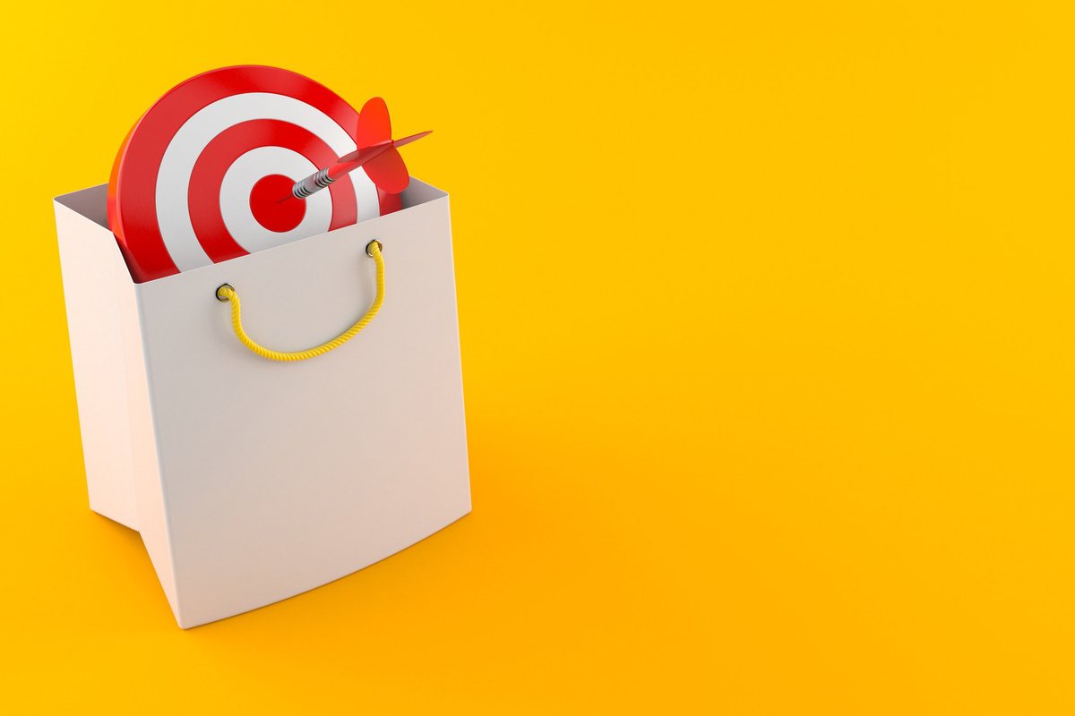 A target in a shopping bag with a dart in the bullseye