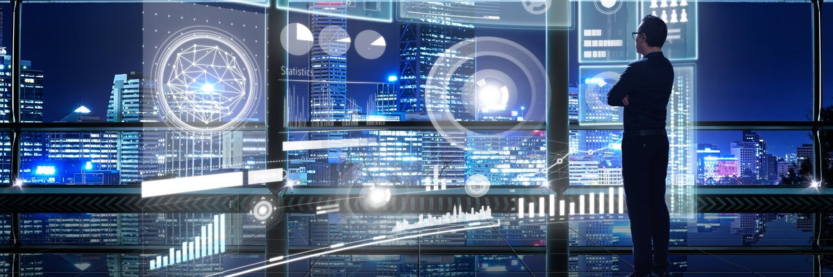 Bespectacled man in black looking at complex network of hologram screens.