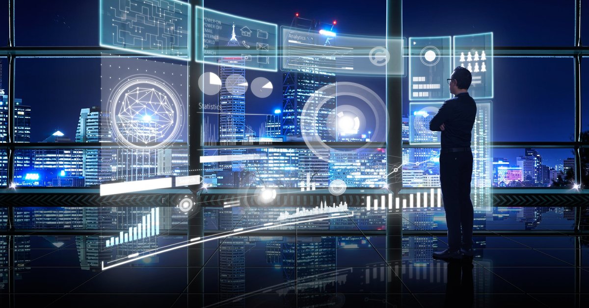 Bespectacled man in black looking at complex network of hologram screens.