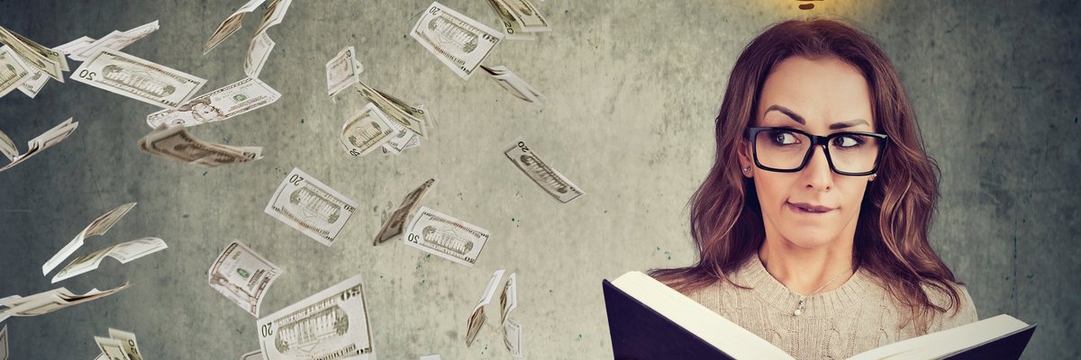 Bespectacled woman opening book and looking over at raining money.