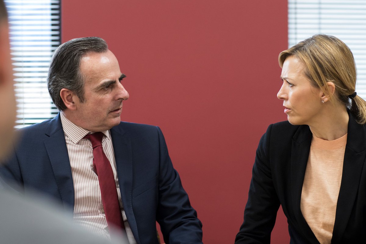 Man and woman looking confrontational in a boardroom.