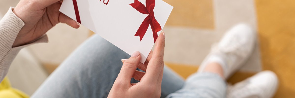 A woman holds a generic gift card.