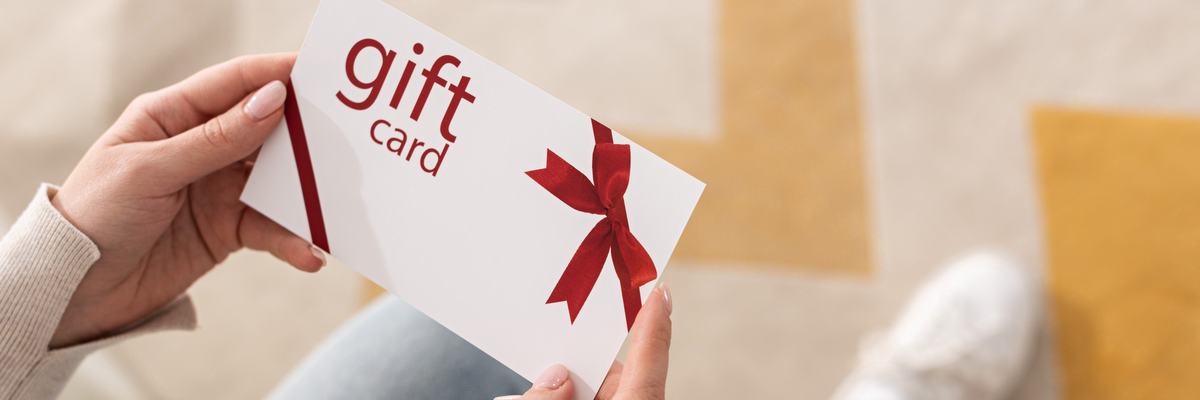 A woman holds a generic gift card.