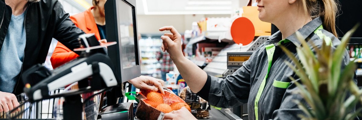 Grocery store employee ringing up customers
