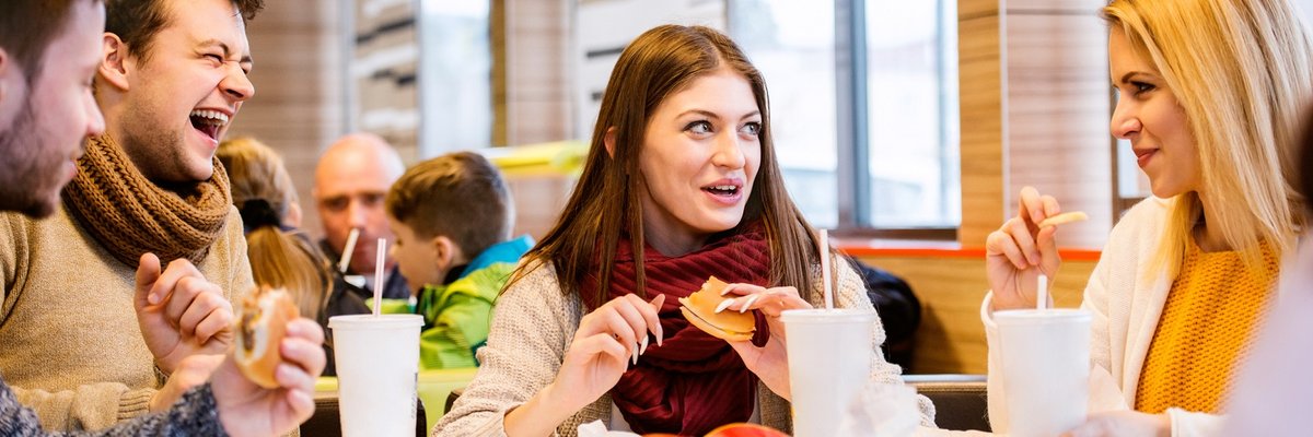 Group of friends eating fast food burgers and fries