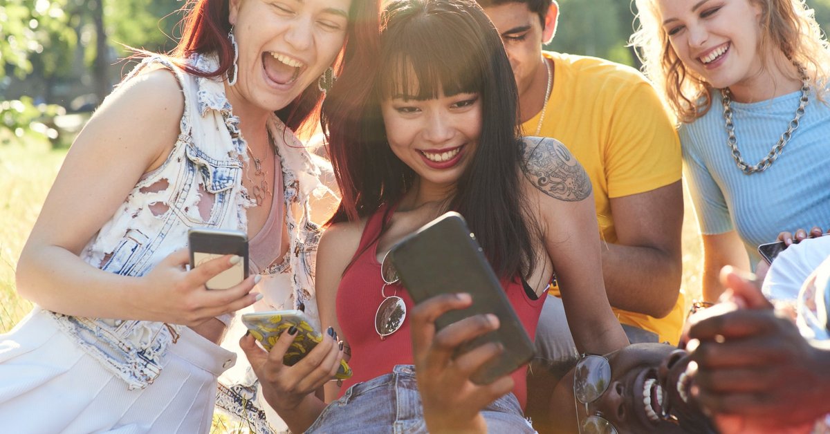 Group of friends hanging out and using their cell phones.