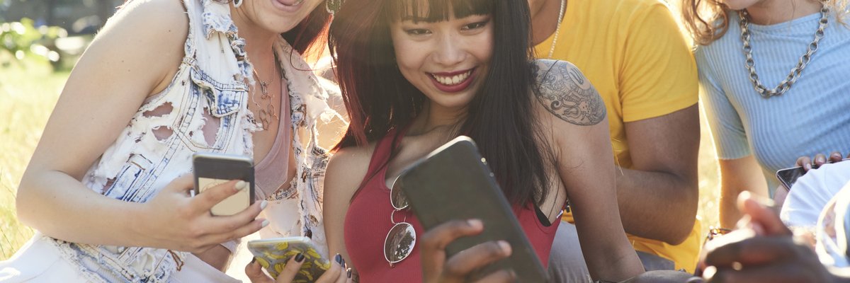 Group of friends hanging out and using their cell phones.