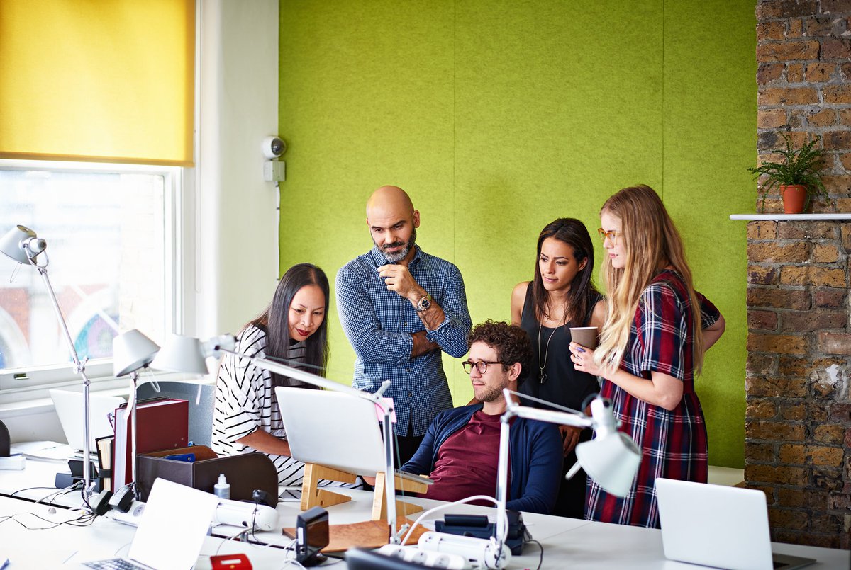 Group of people gathered looking at a computer screen.