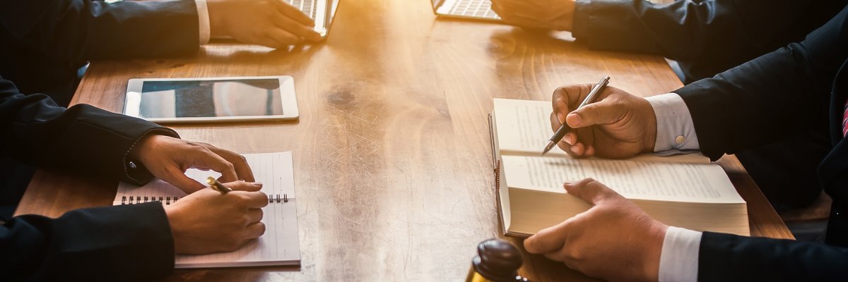 Group of people in suits looking over documents