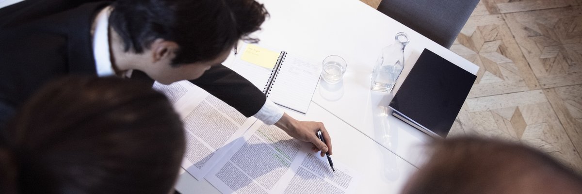 Group of professionals closely reviewing documents.