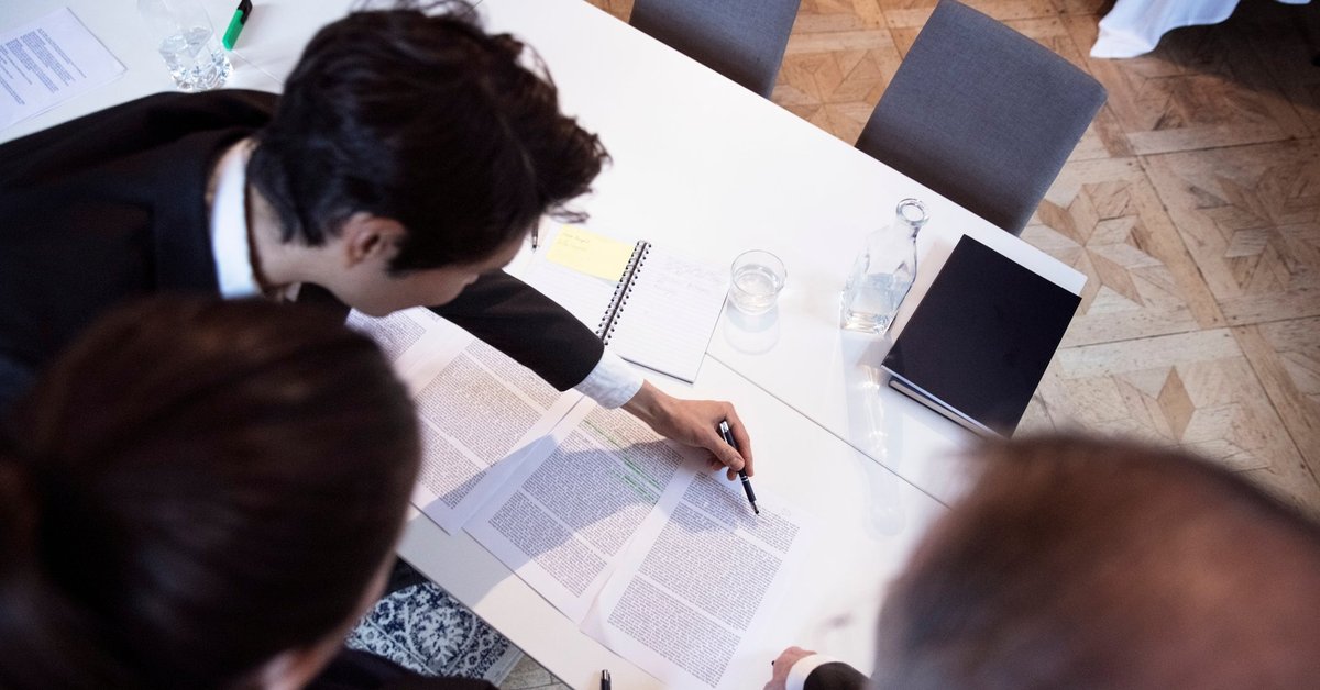 Group of professionals closely reviewing documents.