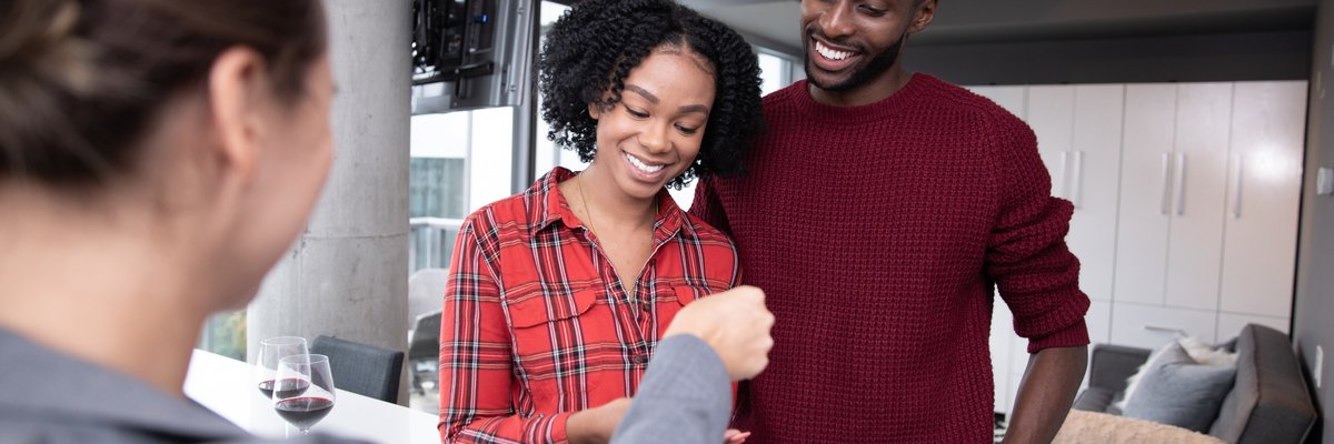 Happy couple receiving keys to their new home.