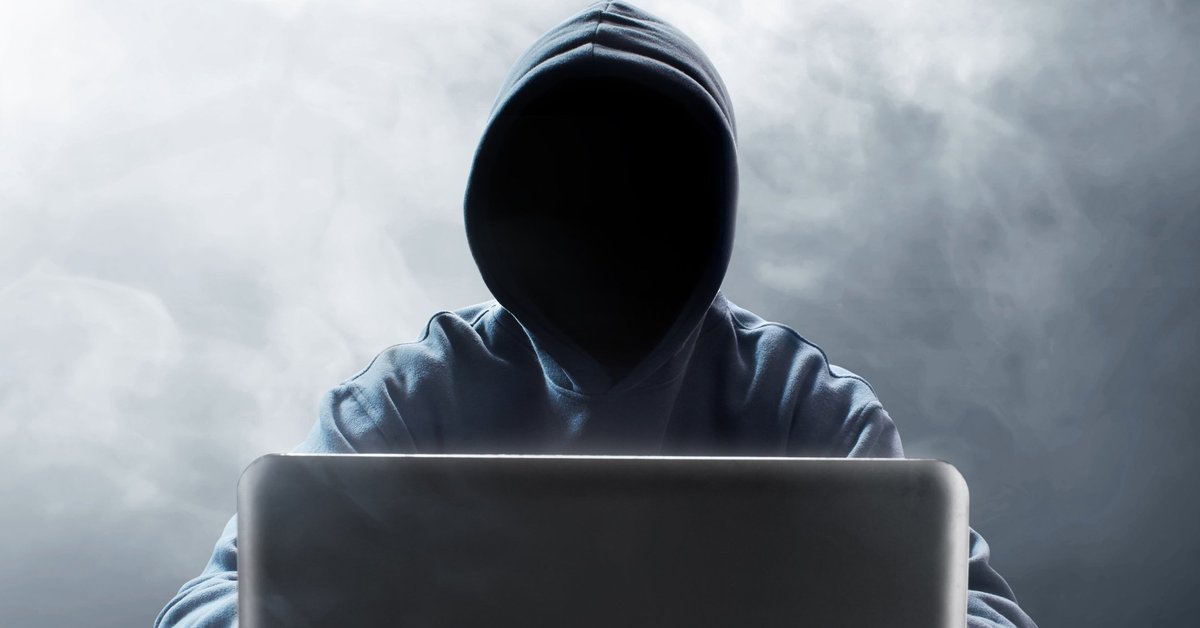 Hooded figure at laptop