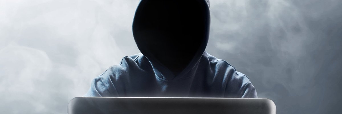 Hooded figure at laptop