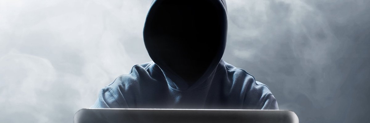 Hooded figure at laptop