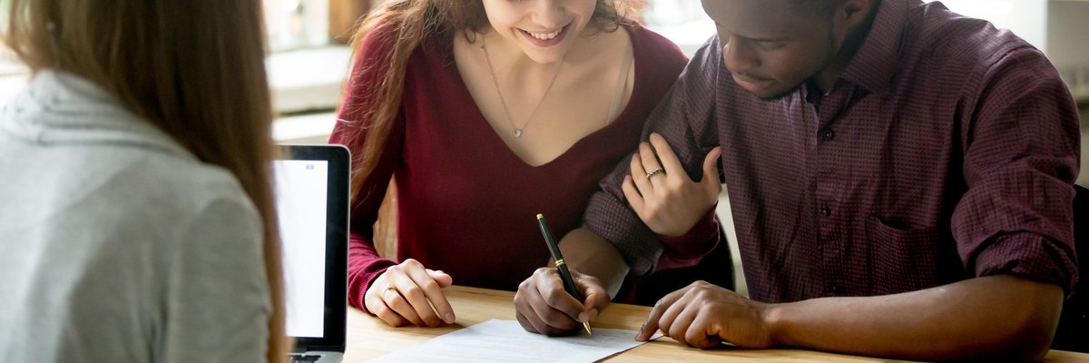 Young couple signing contract.