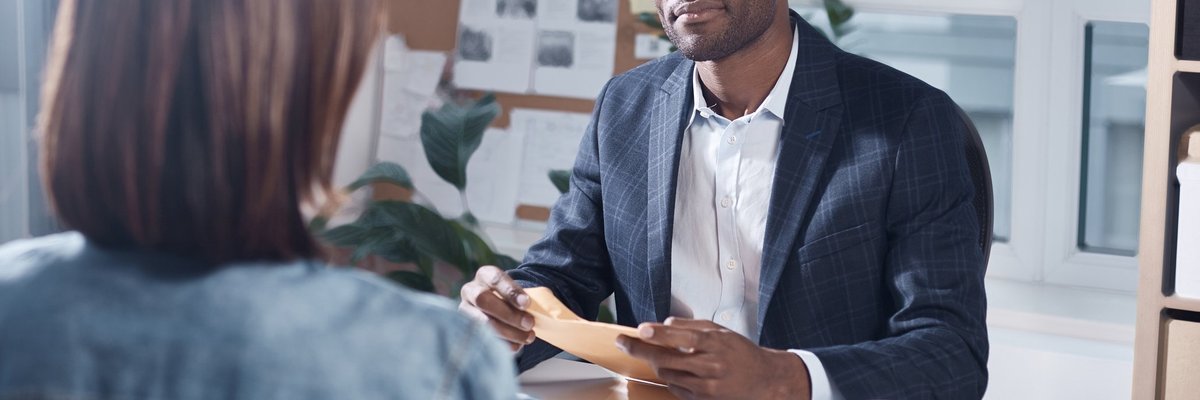 Man holding a folder while having a business meeting with a woman.