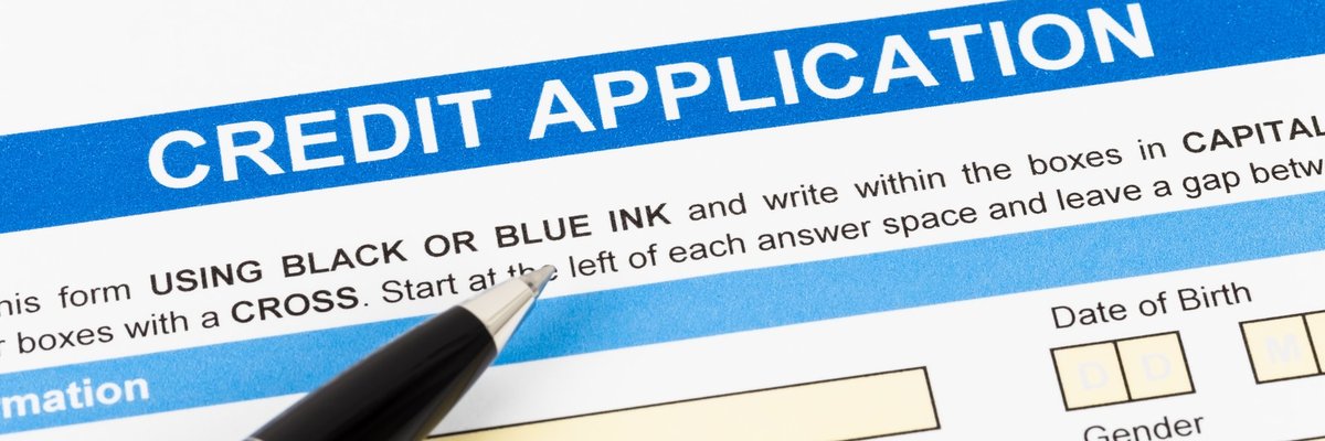 Credit application paperwork with pen lying on top.