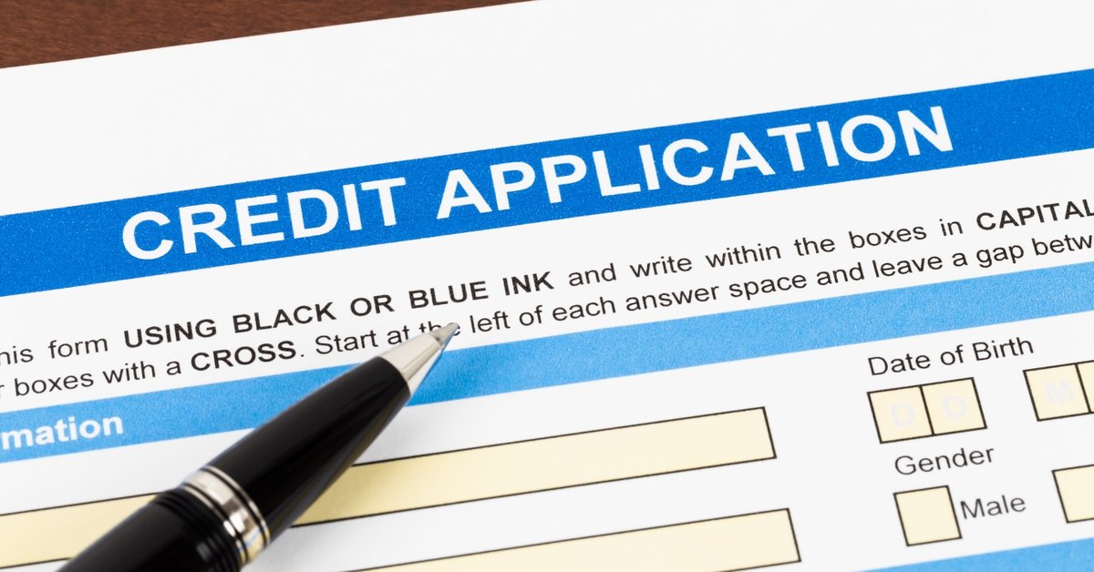 Credit application paperwork with pen lying on top.