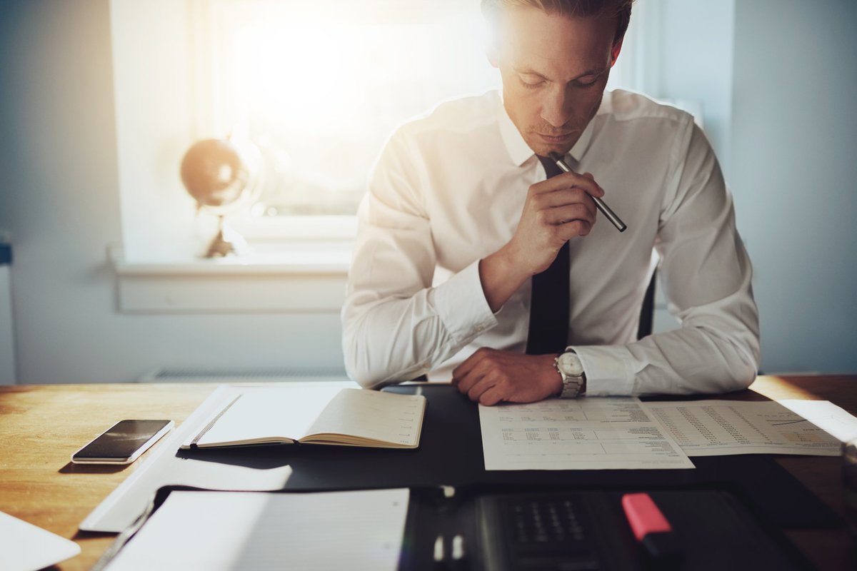 Man reading over documents at a desk.
