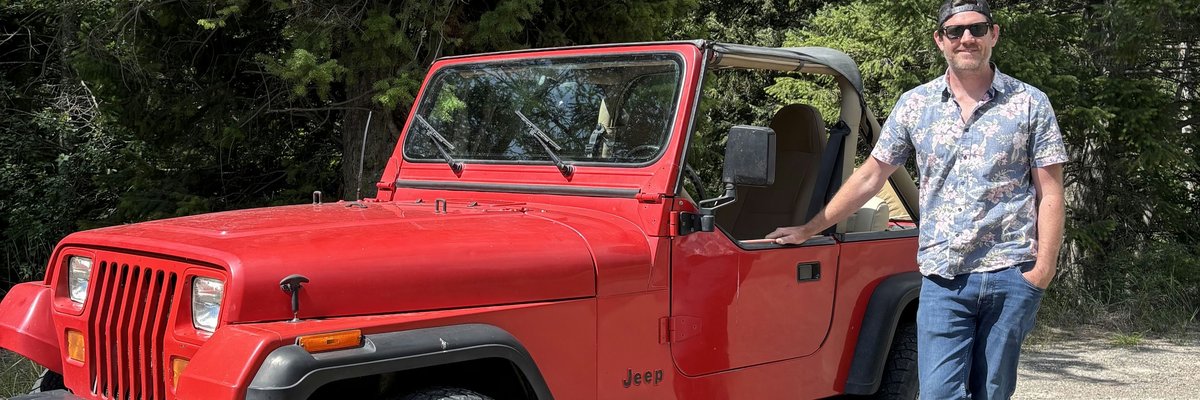 Author Joel O'Leary beside his red Jeep Wrangler.