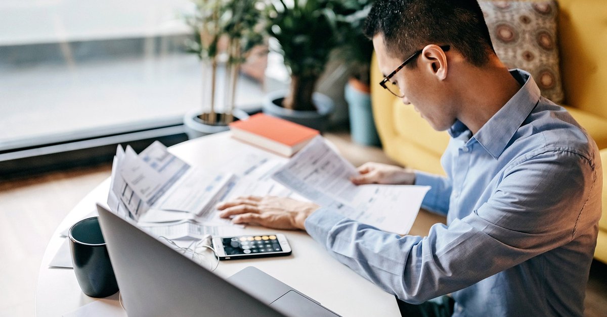 Man using a calculator and looking over documents.